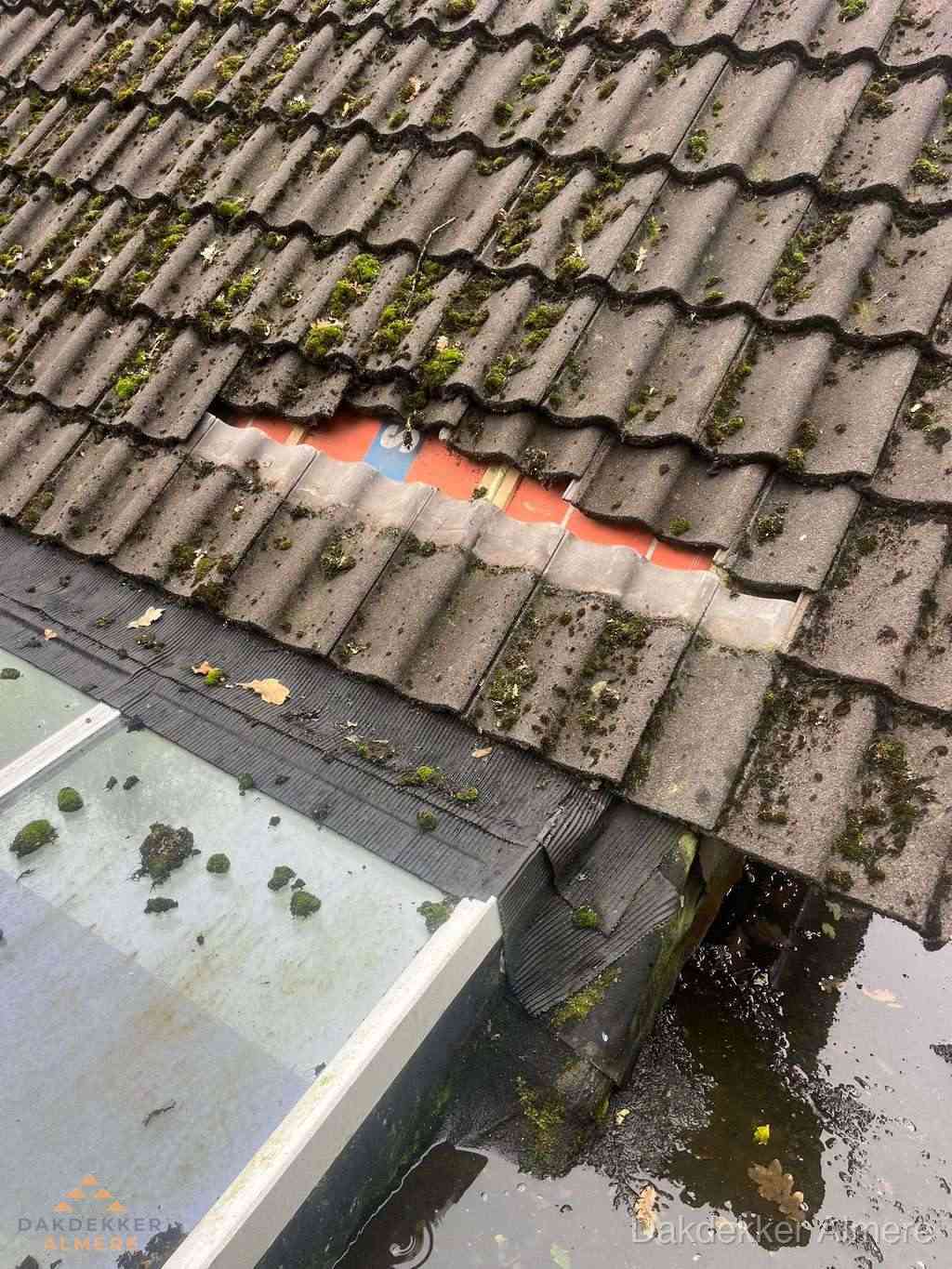 Beschadigd pannendak met ontbrekende dakpannen voor reparatie in Almere