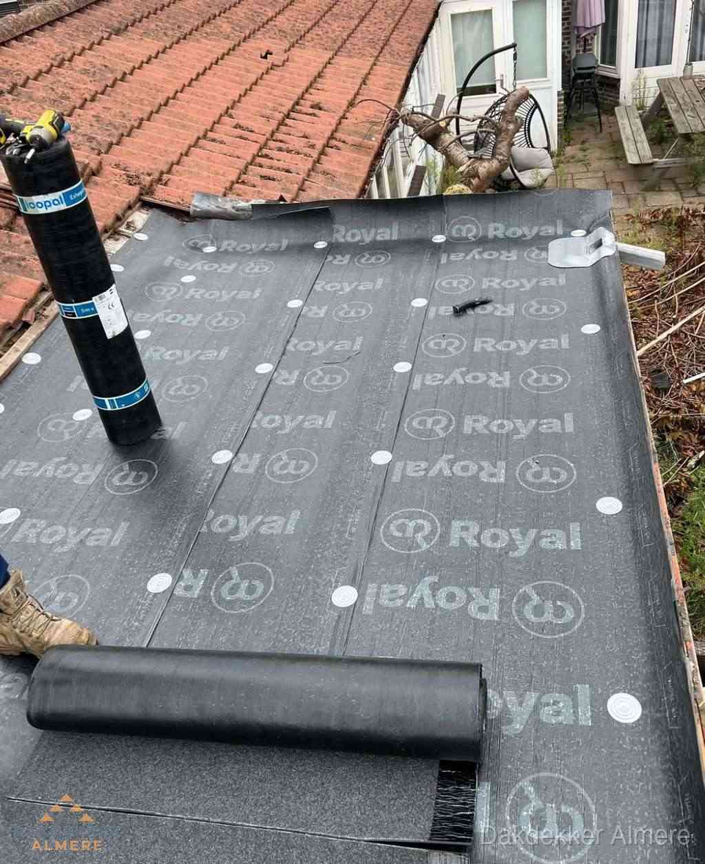 Plat dak met nieuwe bitumen dakbedekking en brandgereedschap in Almere