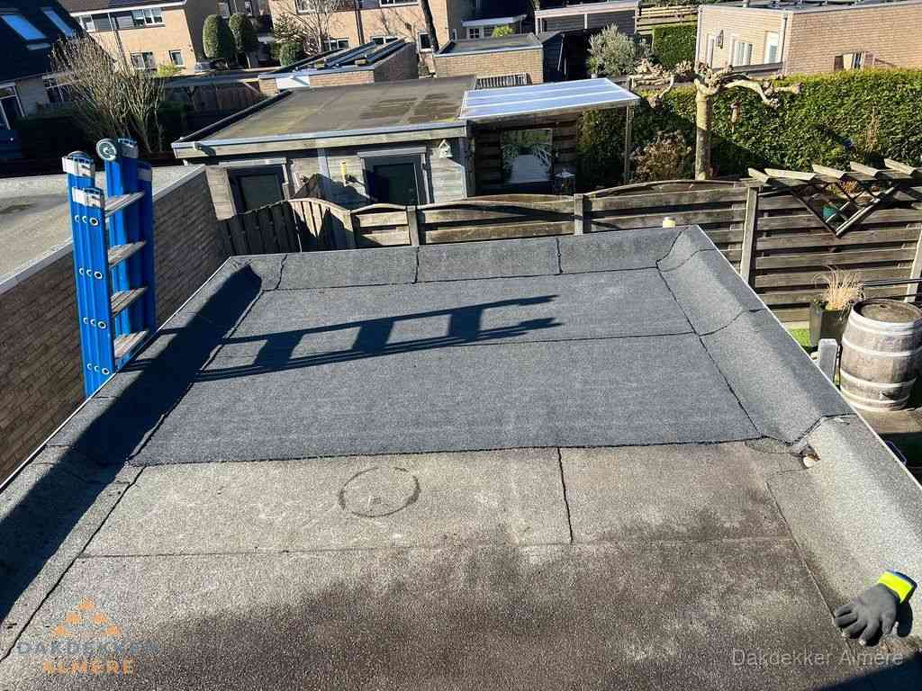 Dakdekker legt onderlaag op plat dak met houten constructie in Almere
