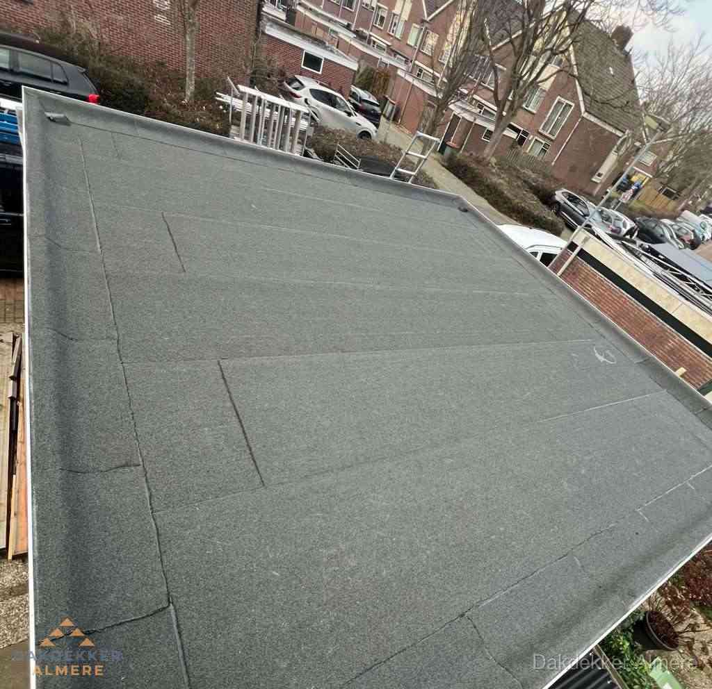 Nieuwe bitumen dakbedekking op plat dak van garage in Almere