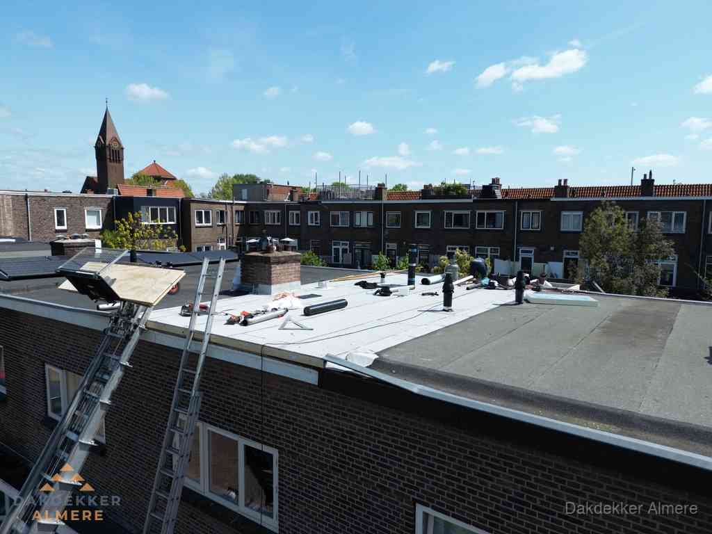 Dakdekkers aan het werk op plat dak in Almere