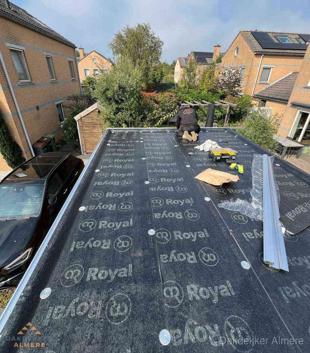 Dakdekker aan het werk op plat dak renovatie in Almere