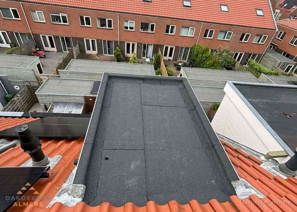 Plat dak met bitumen bedekking naast dakkapel in Almere