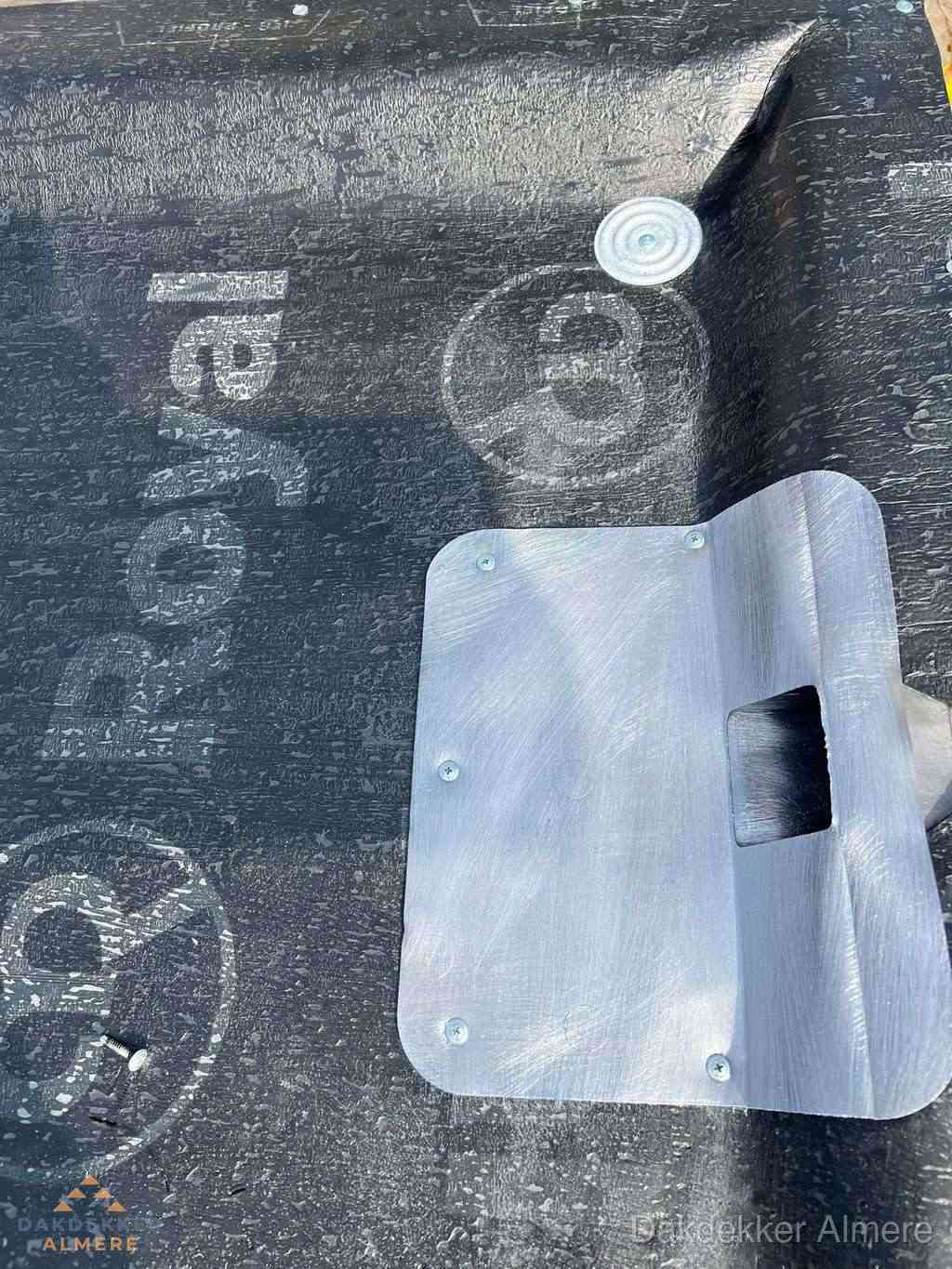 Dakdoorvoer met metalen afvoerplaat op bitumen dak in Almere
