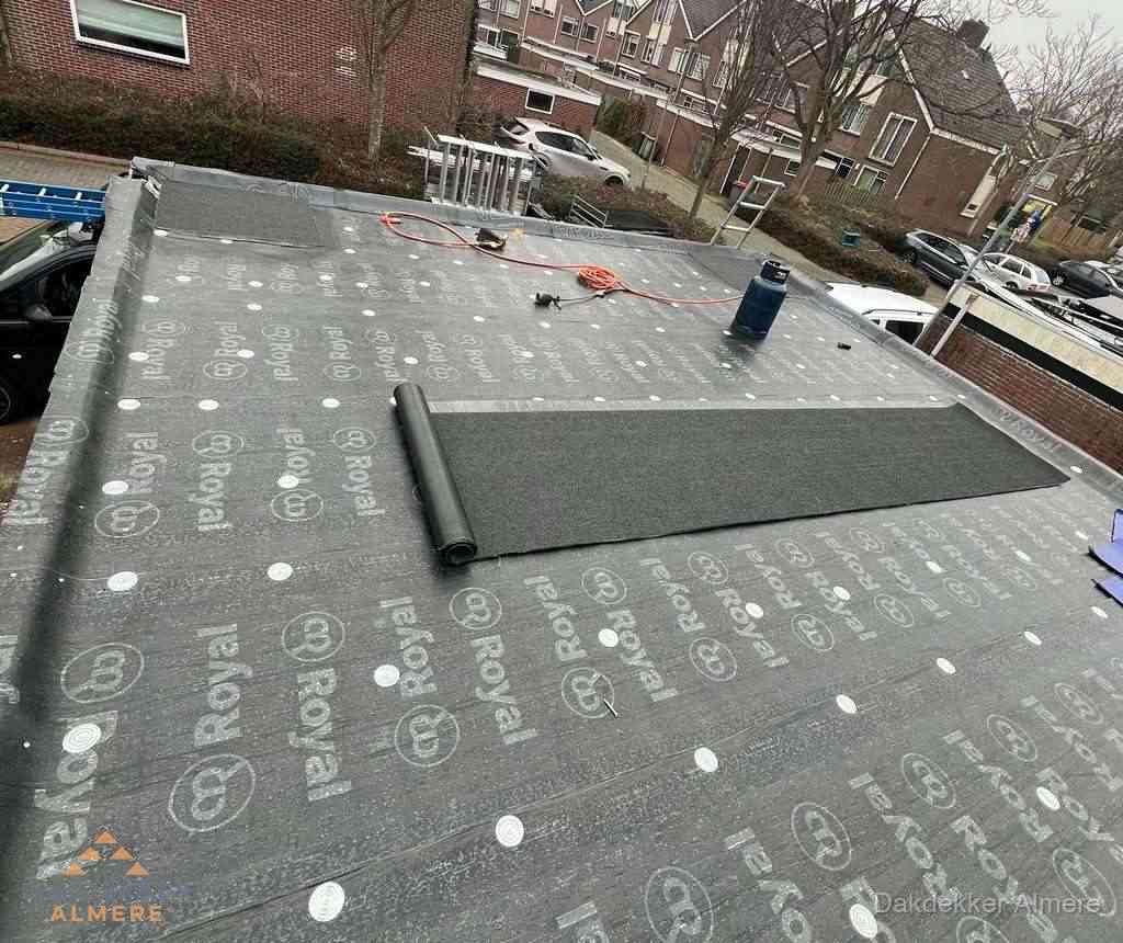 Dakdekker aan het werk met gasbrander op plat bitumen dak in Almere