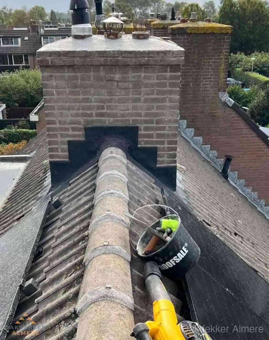 Dakdekker repareert bitumen dakleer bij dakdoorvoer in Almere